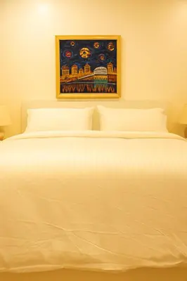 a large white bed with a painting on the wall at Deep Cove holiday in North Vancouver