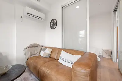 a living room with a brown leather couch at Brand new suite downtown Kelowna - walk everywhere! in Kelowna