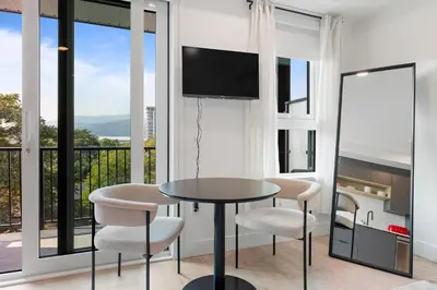 a dining room with a table and chairs and a balcony at Brand new suite downtown Kelowna - walk everywhere! in Kelowna