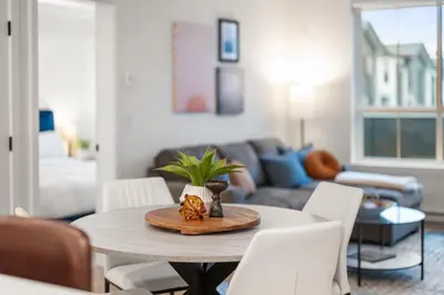a living room with a table and white chairs at Chic Condo with Stylish Amenities in White Rock in Surrey