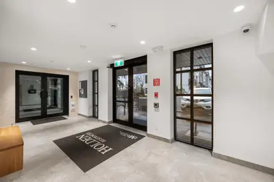 a lobby with glass doors and a black welcome mat at Chic Condo with Stylish Amenities in White Rock in Surrey