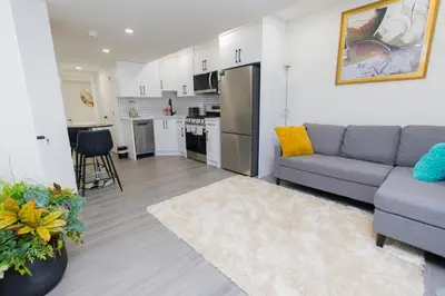 a living room with a couch and a kitchen at Cozy Quarters Your Comfy Haven in Calgary