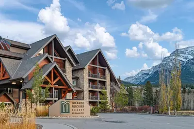 a resort building with mountains in the background at Chic Mountain View - Pool & HotTub - Fireplace - BBQ! in Canmore