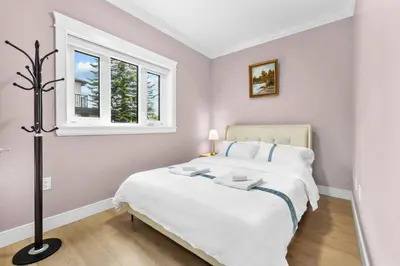 a bedroom with a large white bed and a window at Modern Private 3BR House in Vancouver