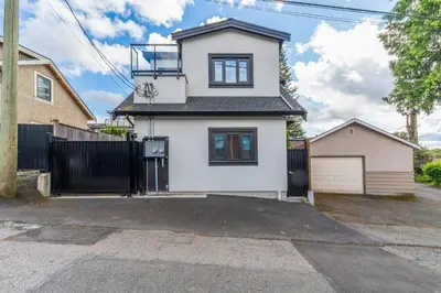 a white house with a black fence at Modern Private 3BR House in Vancouver