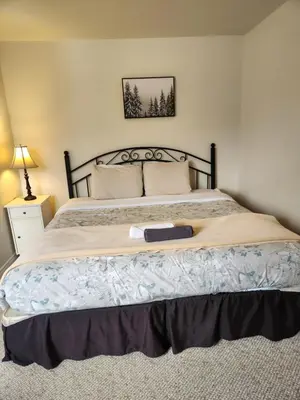 a bedroom with a large bed with a wooden headboard at Alpenrose 204 Hottubs, Mountains View, KING bed in Golden