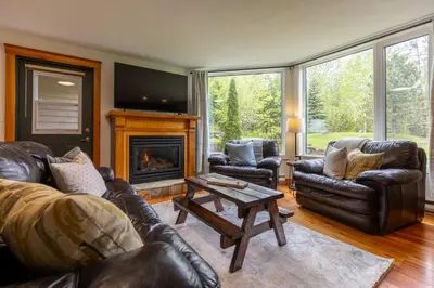 a living room with leather furniture and a fireplace at Timberline - Spruce Lodge by Fernie Central Reservations in Fernie