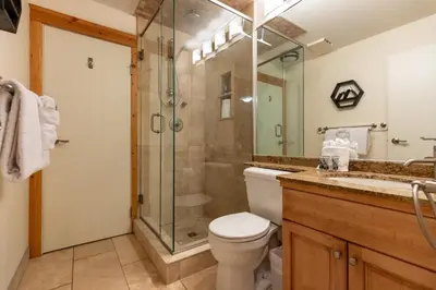 a bathroom with a shower and a toilet and a sink at Timberline - Spruce Lodge by Fernie Central Reservations in Fernie