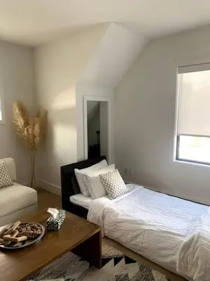 a bedroom with a bed and a table and a window at The White House in Golden