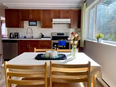 a kitchen with a table with a vase of flowers on it at Urban Retreat in Nanaimo