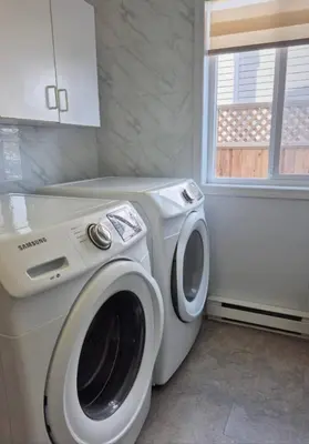 a washing machine in a laundry room with a window at Urban Retreat in Nanaimo