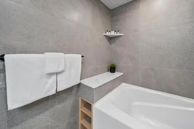 a bathroom with a white tub and a white sink at The Summit Room Whistler Village in Whistler