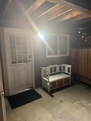 a bedroom with a bed and a door with a light at sweet home in Delta