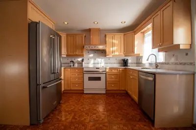 a kitchen with wooden cabinets and a stainless steel refrigerator at Serene Garden Suite in Delta
