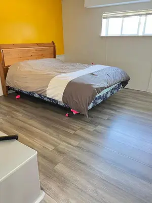 a bedroom with a bed and a wooden floor at Surrey central in Surrey