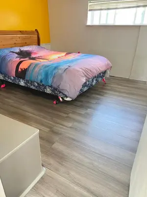 a bedroom with a bed and a wooden floor at Surrey central in Surrey