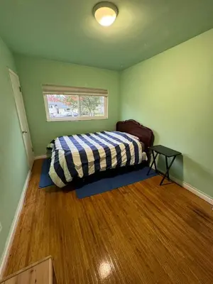 a bedroom with a bed in a green room at surrey central green bamboo house in Surrey