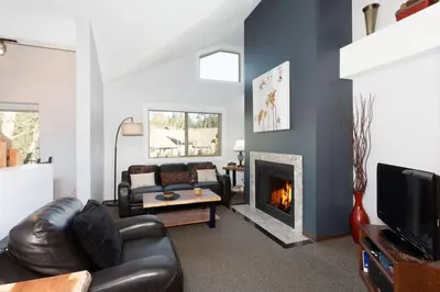 a living room with a couch and a fireplace at Whistler Corner Loft Next to lift with Amazing views! in Whistler