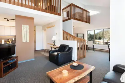 a living room with a couch and a television at Whistler Corner Loft Next to lift with Amazing views! in Whistler