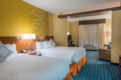 a hotel room with two beds and a couch at Fairfield Inn & Suites by Marriott Kamloops in Kamloops