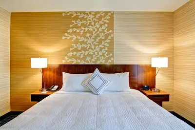 a bedroom with a large bed with two lamps on two tables at Fairfield Inn & Suites by Marriott Kamloops in Kamloops