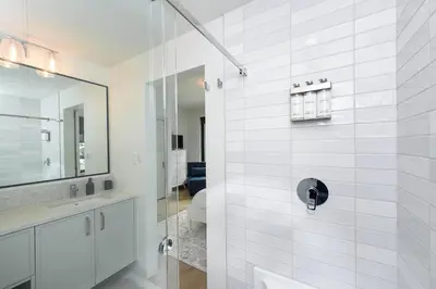 a white bathroom with a shower and a sink at Luxury Saratoga Beach Town Home in Oyster Bay