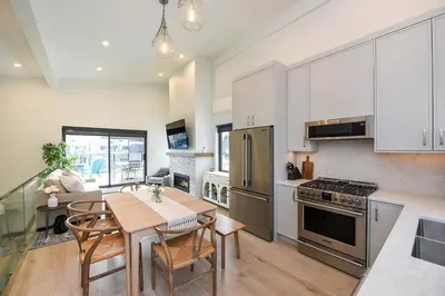 a kitchen and dining room with a table and chairs at Luxury Saratoga Beach Town Home in Oyster Bay