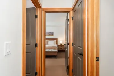 a hallway leading to a bedroom with a bed at Evergreen Escape - 2 Bedroom Condo with Pool & Hot Tub in Canmore