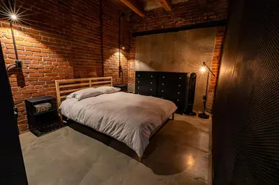 a bedroom with a bed and a brick wall at Stylish Industrial Loft - Historic Gastown in Vancouver
