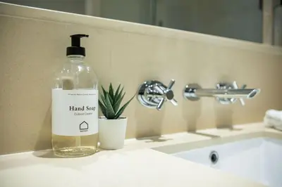 a bottle of hand soap sitting on a bathroom sink at Fitzsimmons Walk 26 by Outpost Whistler in Whistler
