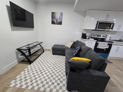 a living room with a couch and a kitchen at Amazing 2-bedroom house with WiFi in Edmonton in Edmonton