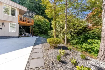 a house with a deck and a driveway at Spacious 3Bedrooms Family Getaway in North Vancouver in North Vancouver