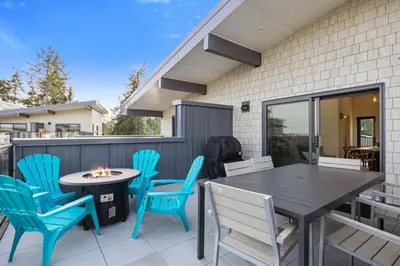 a patio with blue chairs and a table and a table and chairs at Family-Friendly Beachside Bliss in Oyster Bay