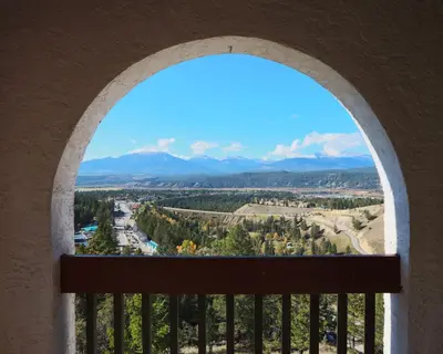an arched window with a view of the mountains at Radium Chalet in Radium Hot Springs