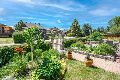 a garden with a gate and many plants at Centrally located 1 Bed 1 Bath Ensuite Cute Guest Suite Private Laundry Pet OK in Calgary