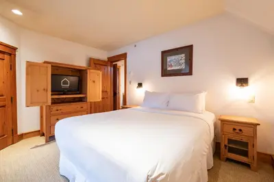 a bedroom with a white bed and a tv at Foxglove 16 by Outpost Whistler in Whistler