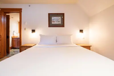 a large white bed in a room with two lamps at Foxglove 16 by Outpost Whistler in Whistler
