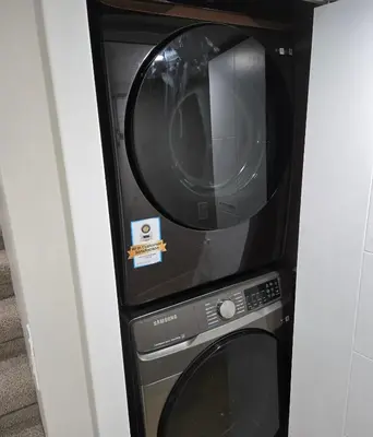 a black microwave oven sitting next to a dishwasher at Cozy 2 bedroom basement with side entrance in Bélanger