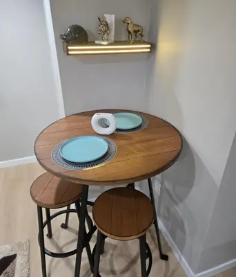 a wooden table with two stools in a room at Cozy 2 bedroom basement with side entrance in Bélanger