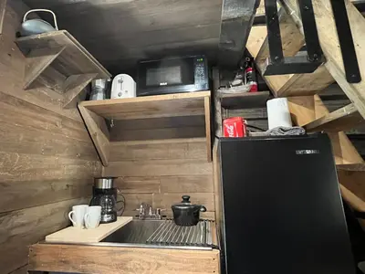 a small kitchen with a sink and a refrigerator at Rustic Guesthouse in Sayward