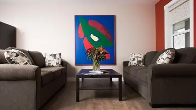 a living room with two couches and a table with flowers at Klippers Guest Suites in Cawston