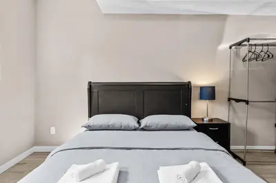 a bedroom with a large bed with two white towels at Cozy 2BR Suite Near White Rock Beach in Surrey