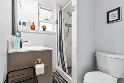 a bathroom with a toilet and a sink and a shower at Cozy 2BR Suite Near White Rock Beach in Surrey