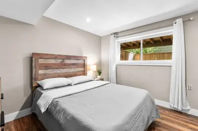 a bedroom with a large bed and a window at Cozy 2BR Suite Near White Rock Beach in Surrey