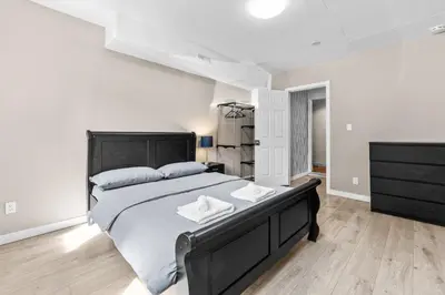 a bedroom with a large bed with two towels on it at Cozy 2BR Suite Near White Rock Beach in Surrey