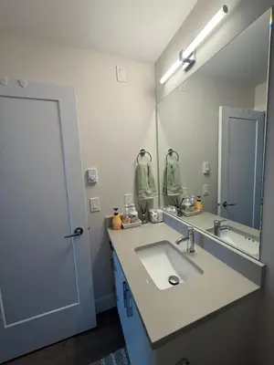 a bathroom with a sink and a large mirror at Ventura in Downtown in Abbotsford