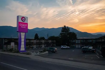 a sign for a guest house in a parking lot at Coast Penticton Hotel in Penticton