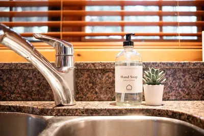 a bottle of hand soap sitting on a kitchen sink at Heron Chalet by Outpost Whistler in Whistler