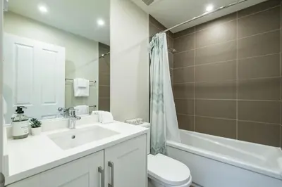 a bathroom with a sink and a toilet and a tub at Lake Placid Lodge 18 by Outpost Whistler in Whistler