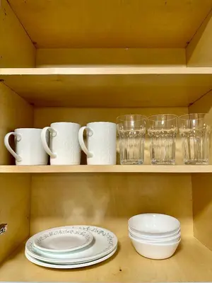 a shelf with cups and plates and glasses on it at Private Entire Guest Suite, 1 min to bus stops to Downtown and major attractions in Vancouver